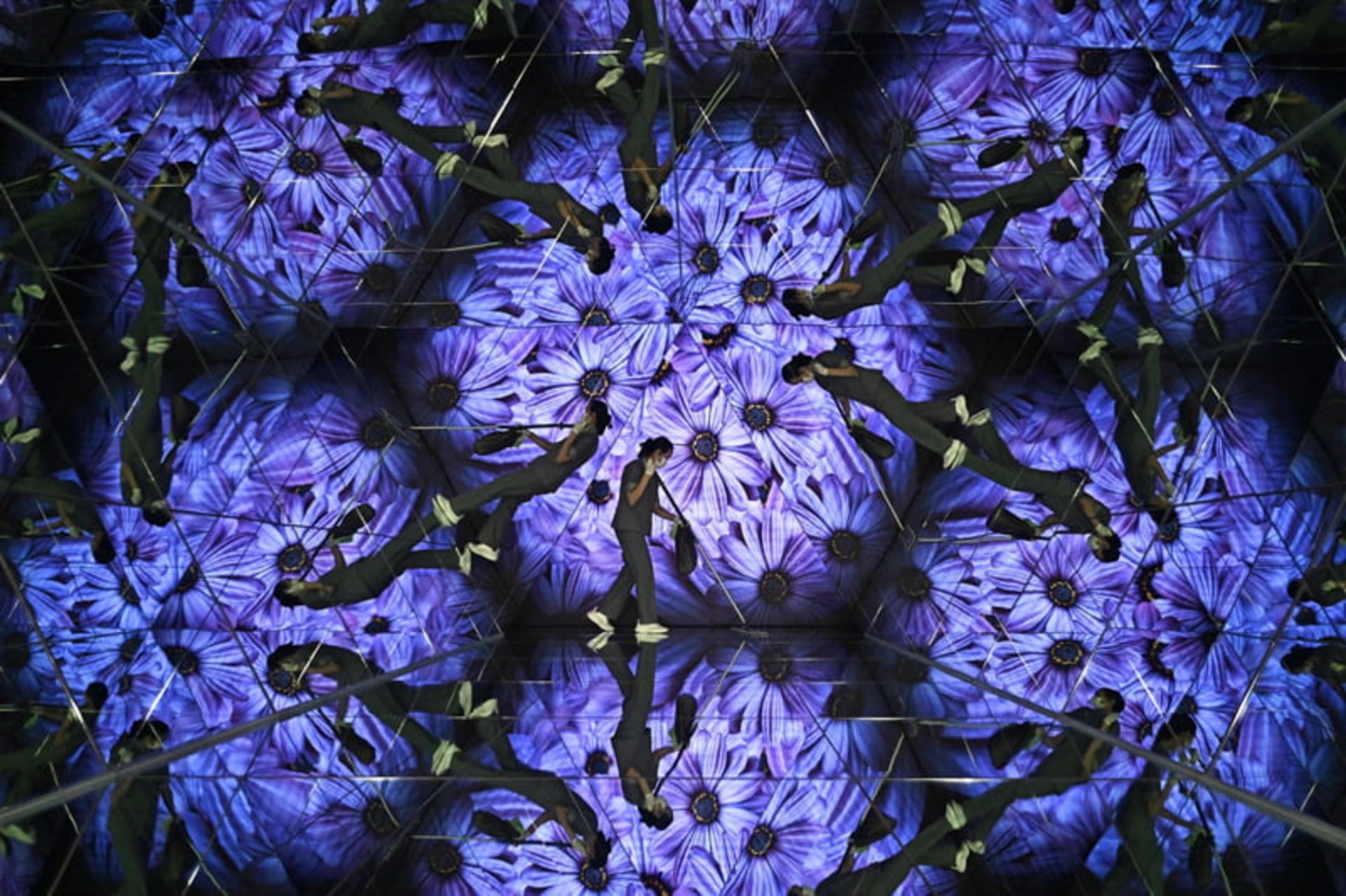 جهان در قاب هفته؛ روایتهایی دیدنی از زندگی در گوشه و کنار دنیا 16 یک کارمند در حال تمیز کردن کف آینه دار در نمایشگاه هنر دیجیتال بانکوک، تایلند