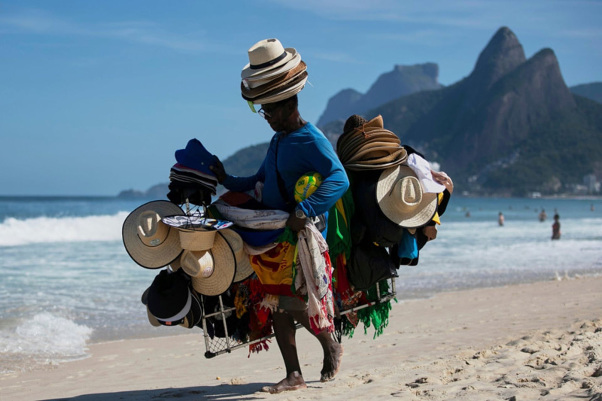 جهان در قاب هفته؛ روایتهایی دیدنی از زندگی در گوشه و کنار دنیا 9 فروشنده ای با کلاه و لباس های ساحلی در ریودوژانیرو، برزیل