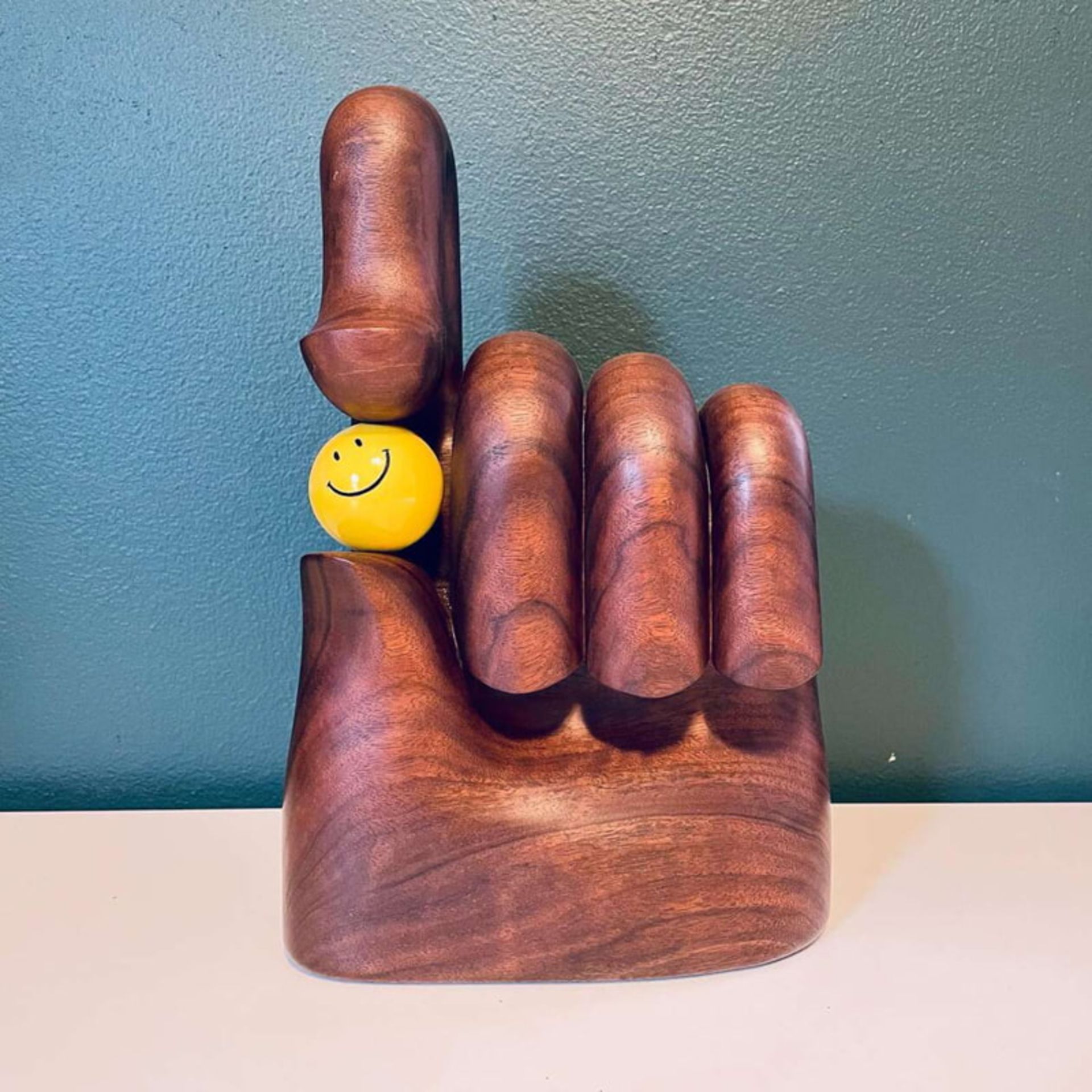 گوی زرد در میان دست چوبی