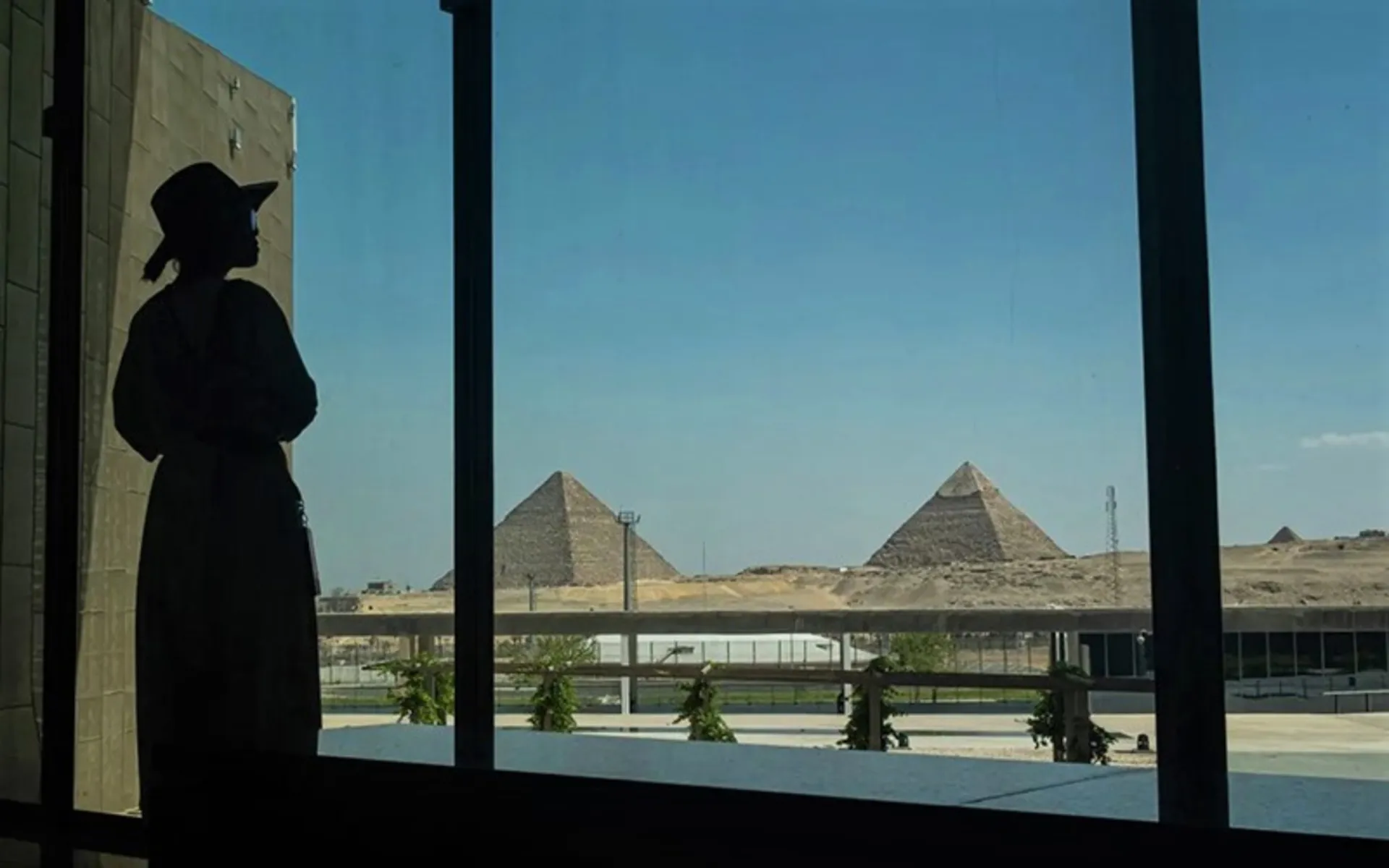 گردشگر زن در حال تماشای اهرام مصر از موزه بزرگ مصر