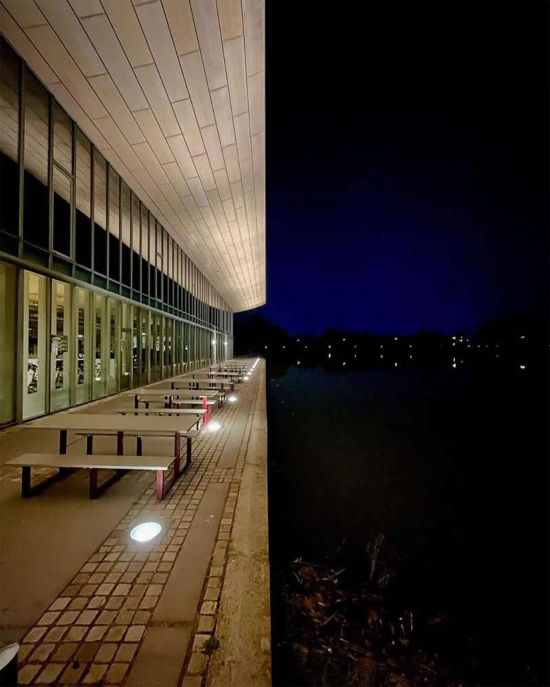 ترکیبی از تاریکی فضای شهری و ساختمان چوبی روشن در شب