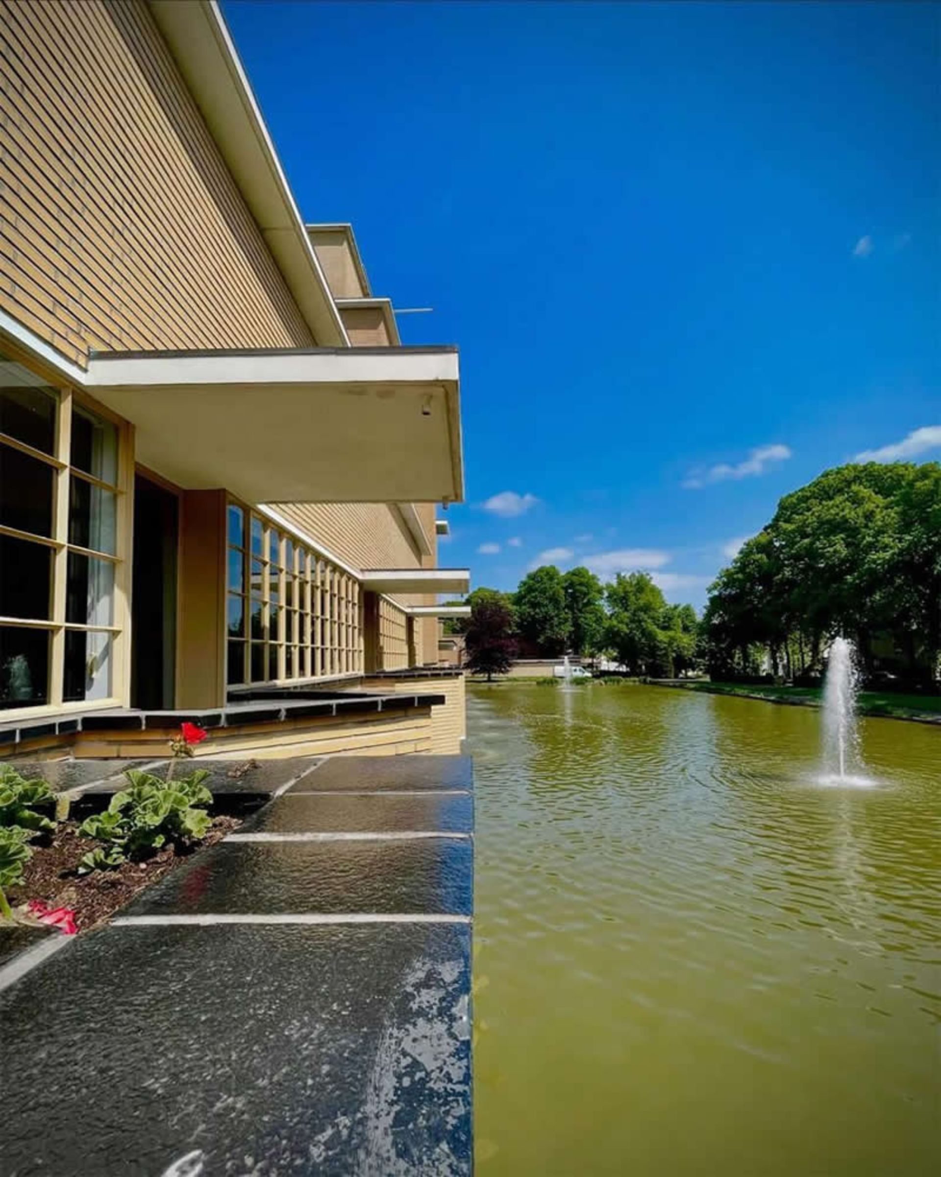 تصویر دوگانه از استخر و فواره آب و ساختمان چوبی