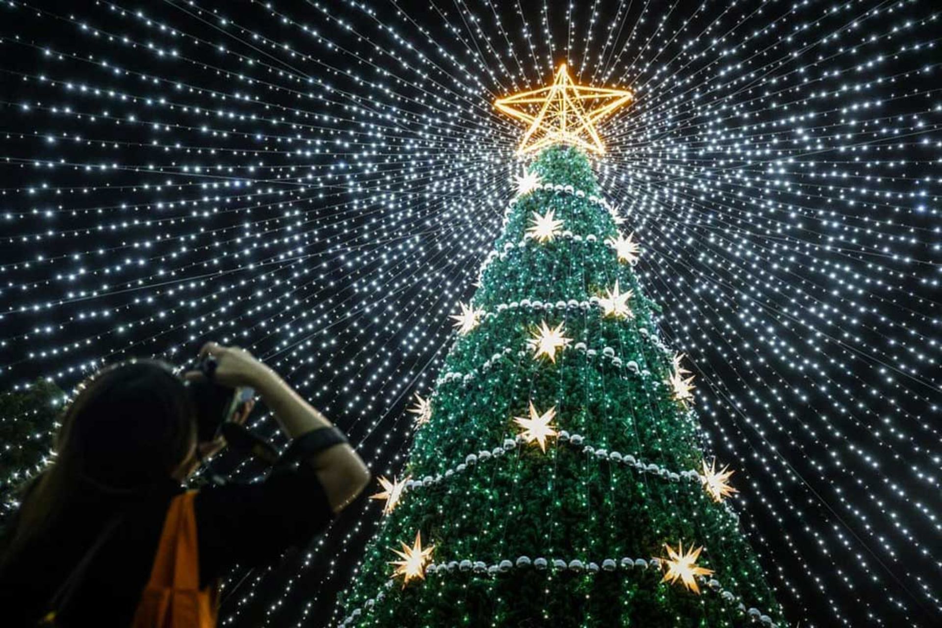 زنی در حال عکس گرفتن از تزئینات کریسمس در تایوان