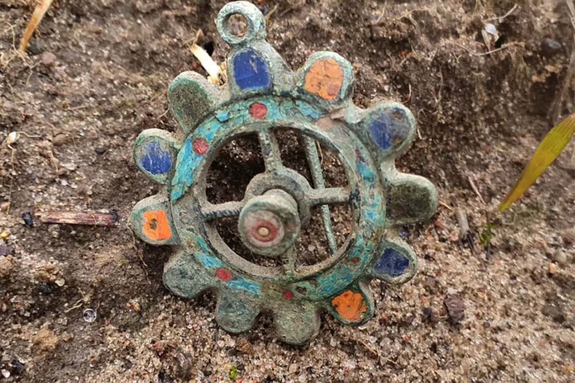 کشف زیور باستانی از دوره روم؛ سنجاق سینه یا طلسم؟ 3 نمای بالای فیبولای میناکاریشده روی خاک