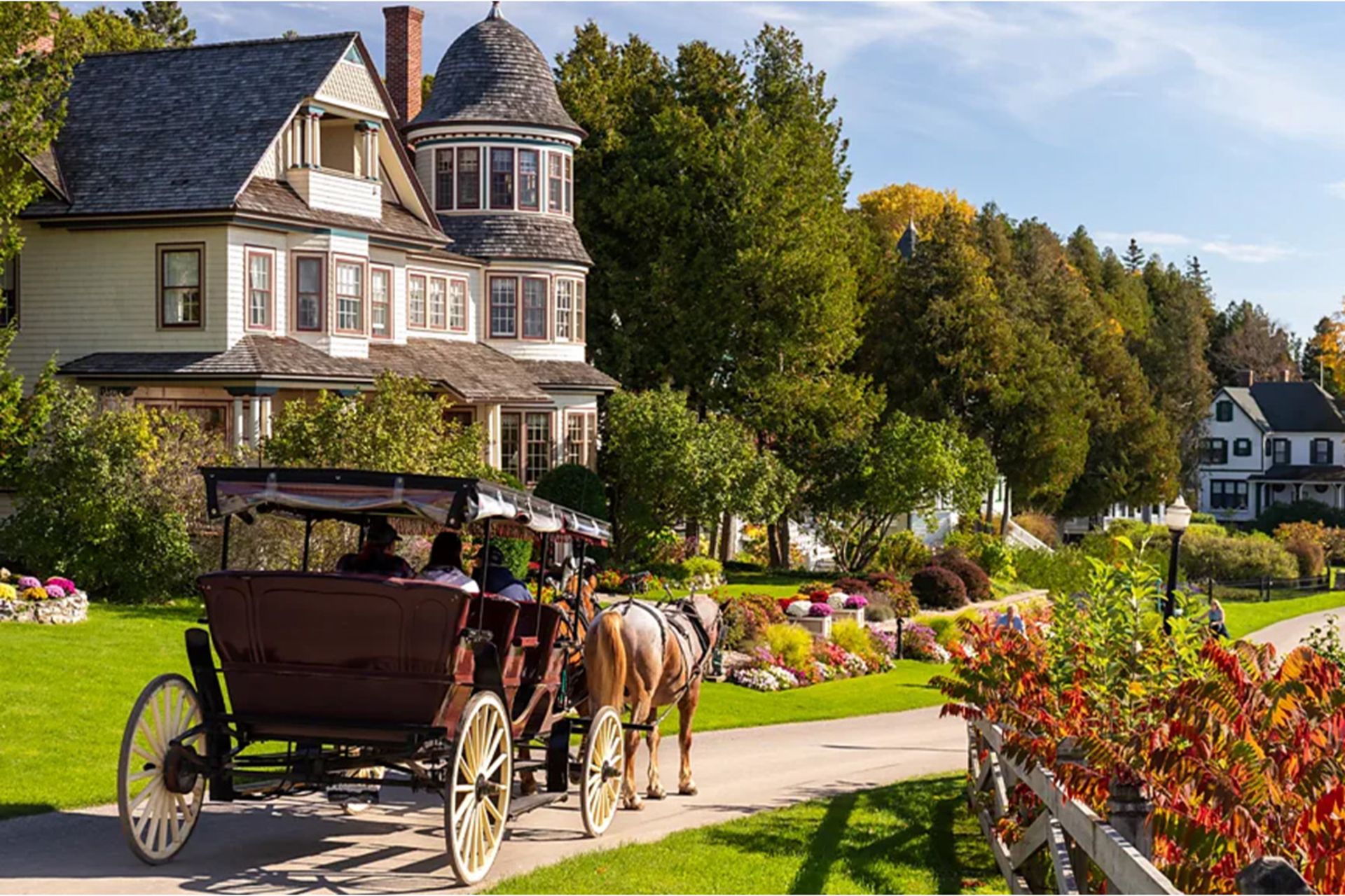 جزیره بدون خودرو آمریکا؛ اینجا مردم در گذشته زندگی میکنند 3 کالسکه اسبی در حال عبور از کنار خانههای سنتی جزیره مکیناک