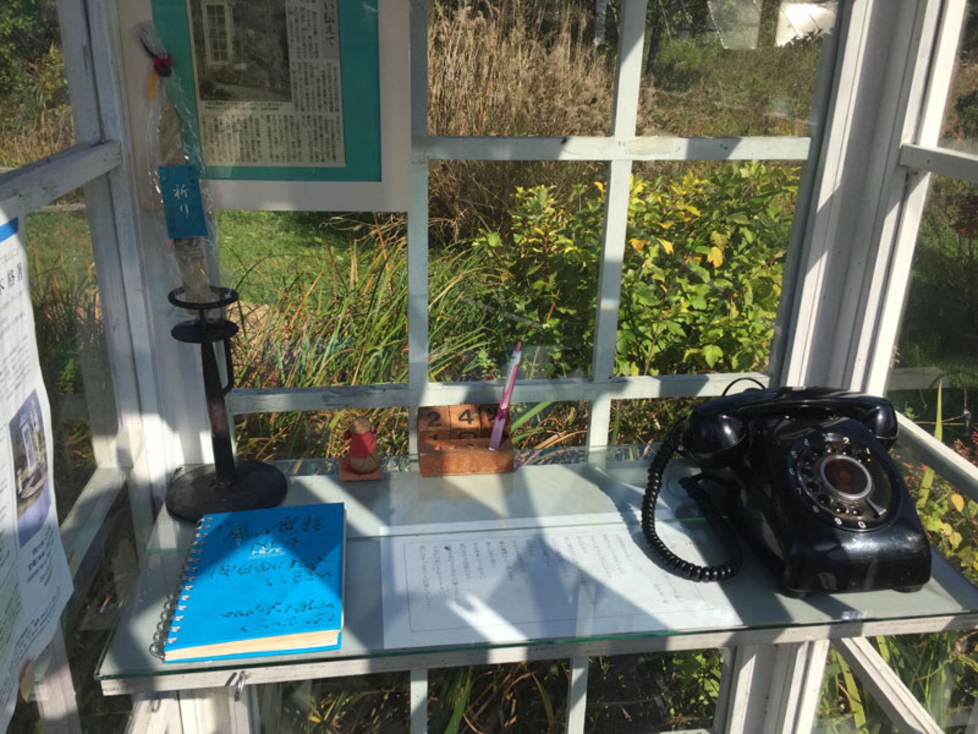 تلفن سیاه قدیمی و دفترچه یادداشتی آبی‌رنگ