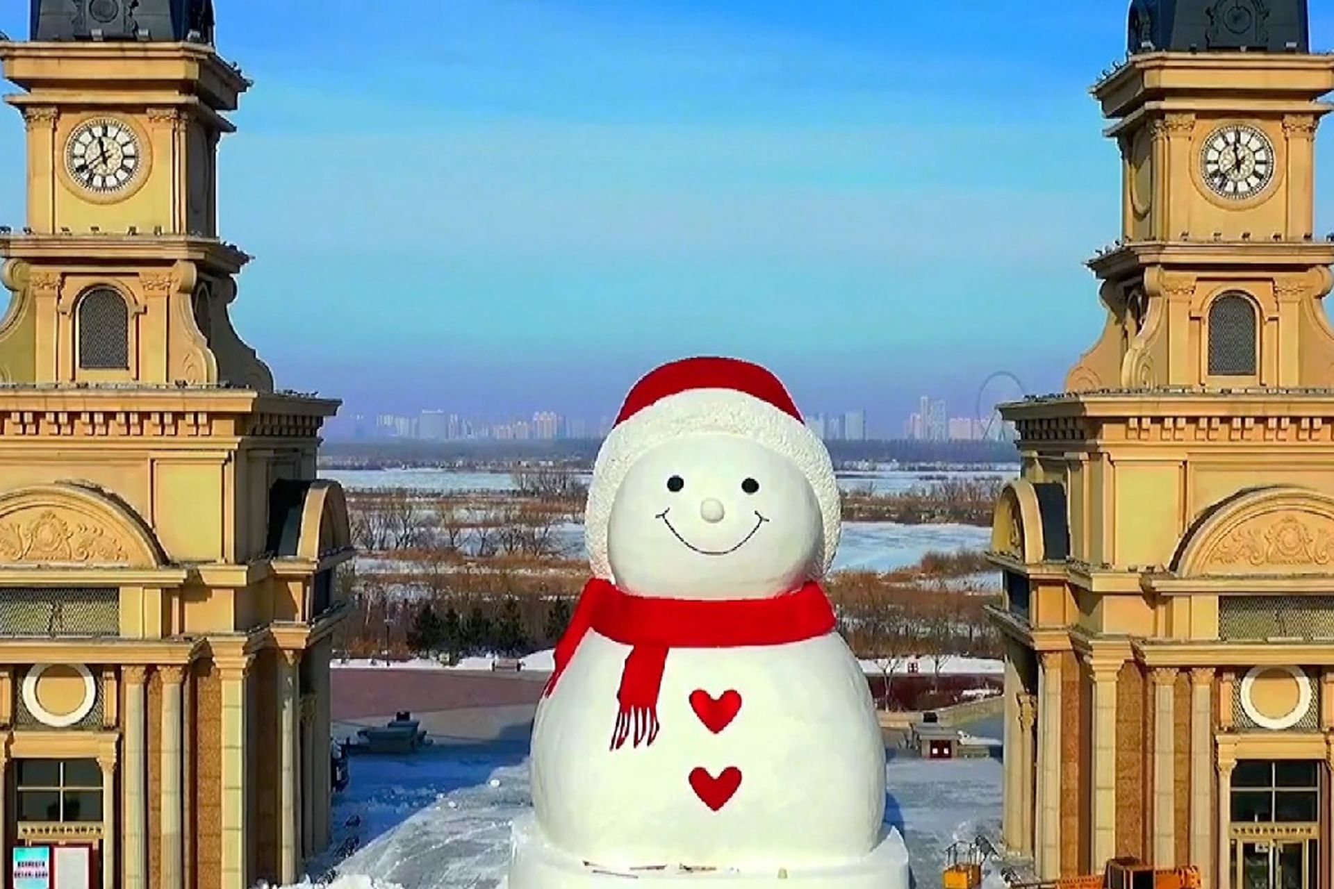 آدم برفی عظیم خندان در میان دو ساختمان در شهر هاربین