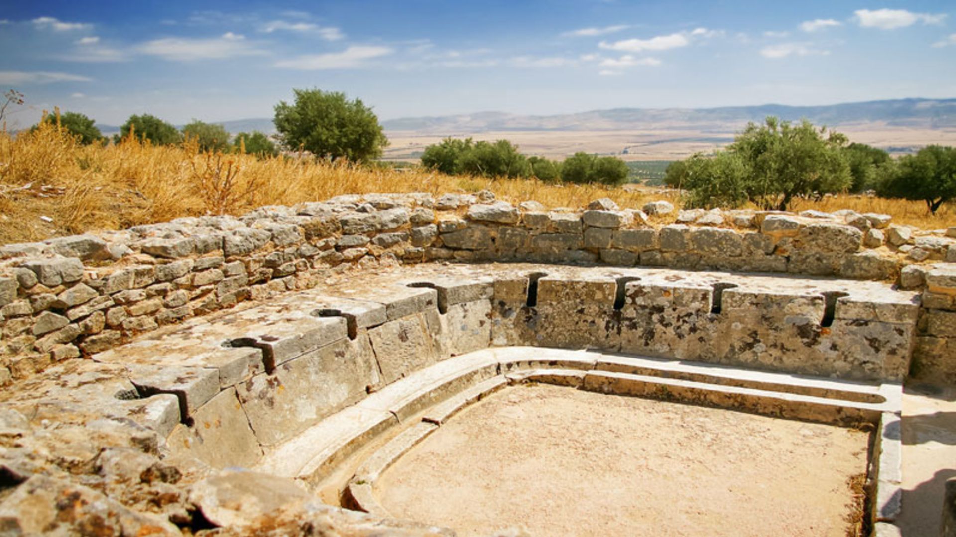 بقایای به جا مانده از یک توالت سنگی دست‌جمعی در فضای باز