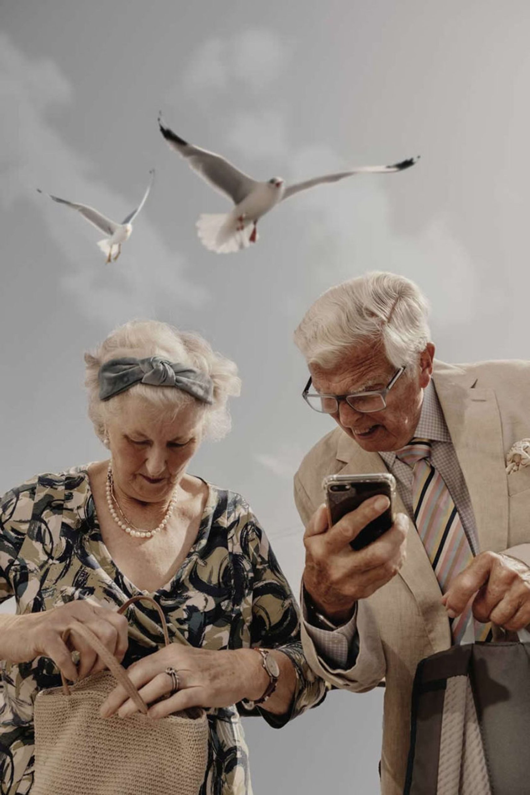 پرواز کبوترها بالای سر زوج کهنسال