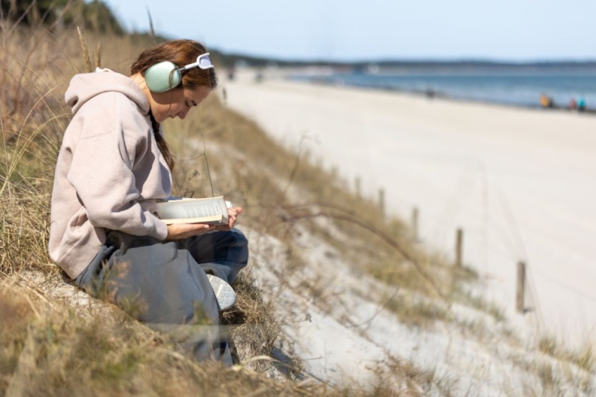 زنی مشغول مطالعه در ساحل