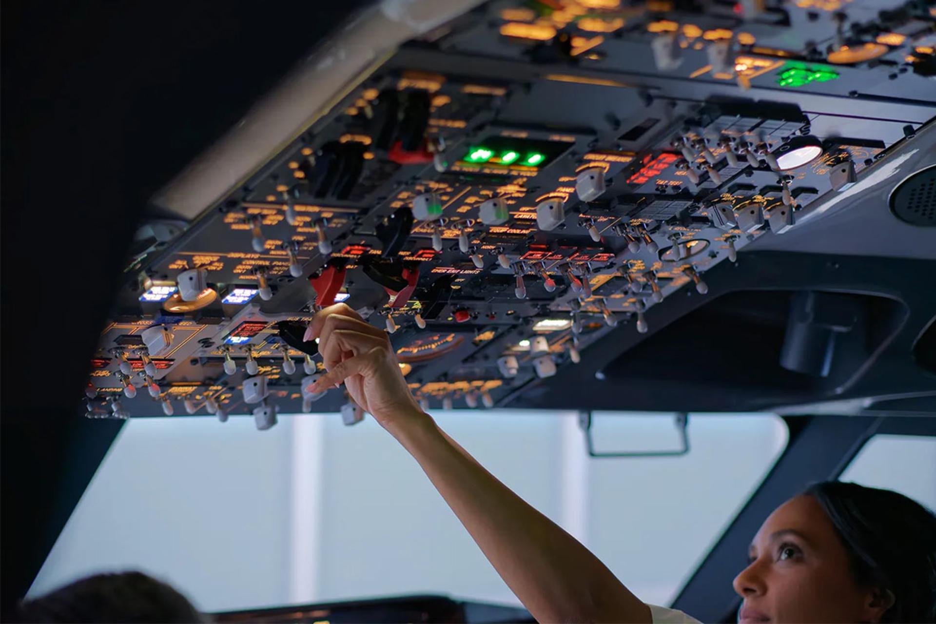 یک خلبان زن در حال تنظیم  یک کلید یا اهرم 