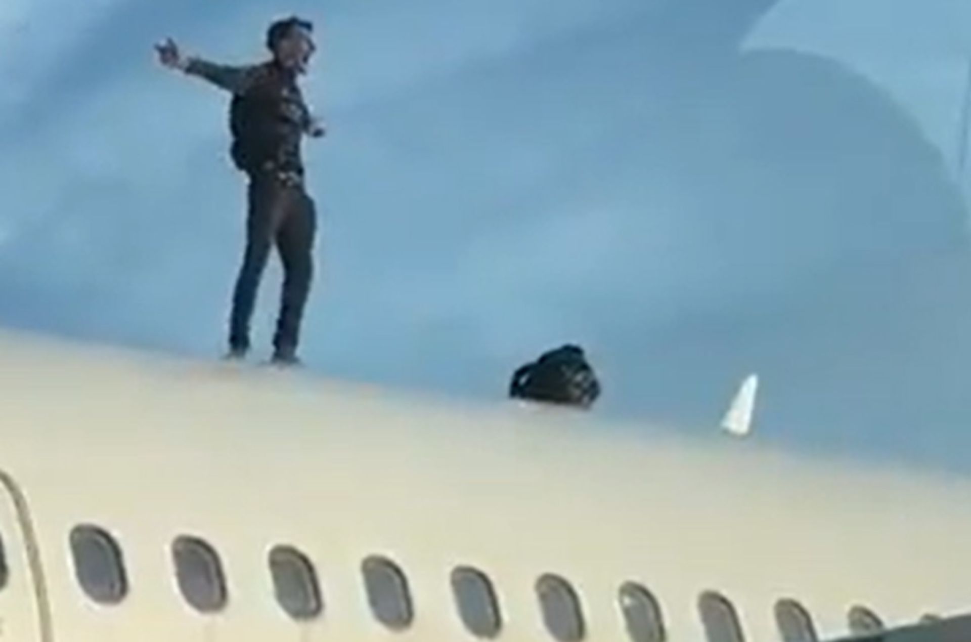 مردی روی سقف یک هواپیما ایستاده است