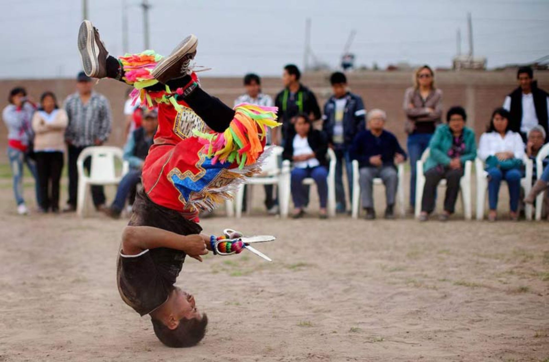 رقاص رقص قیچی در حال اجرای حرکت آکروباتیک روی سر